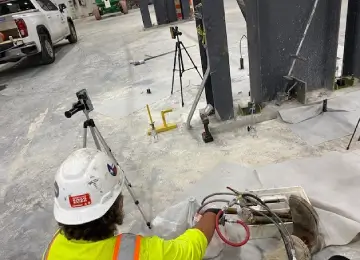 Worker using equipment at industrial construction site.